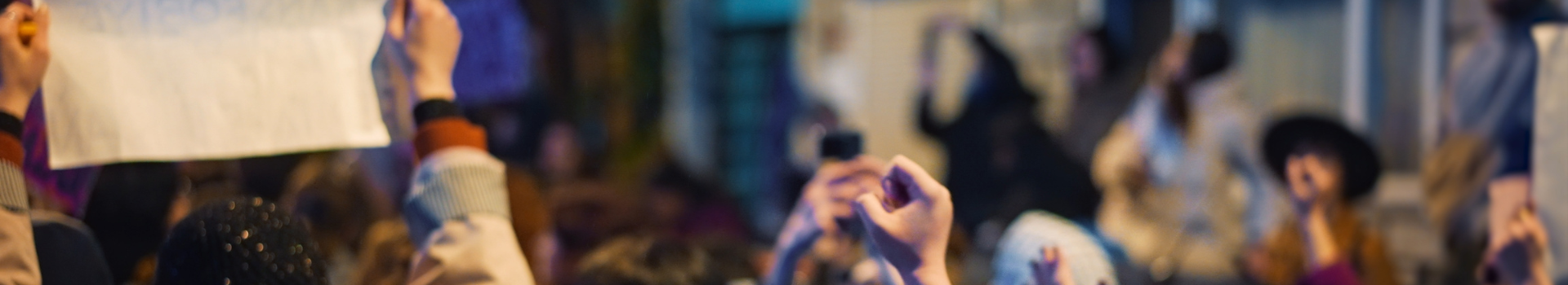 Een groep jongeren betoogt 's avonds op straat.